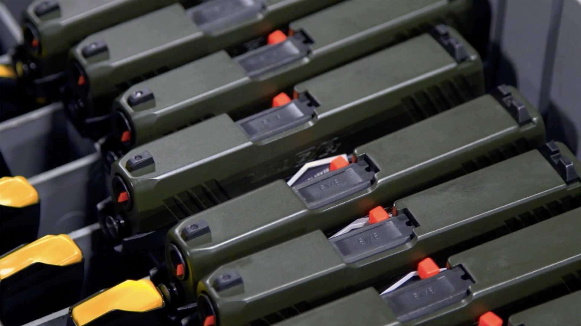 A lineup of OD green-colored Taurus GX4 pistols being readied for shipment.