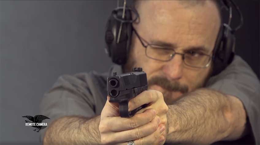 FN 509 held in the hands of a shooter pointing the gun downrange.