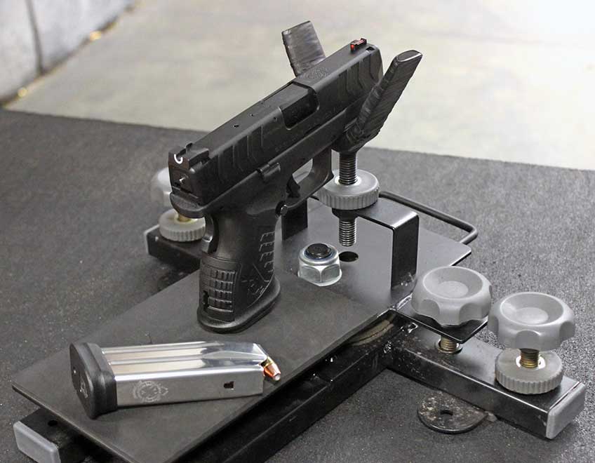 Springfield Armory XD-M Elite 3.8&quot; Compact in cradle on target range shooting bench magazine
