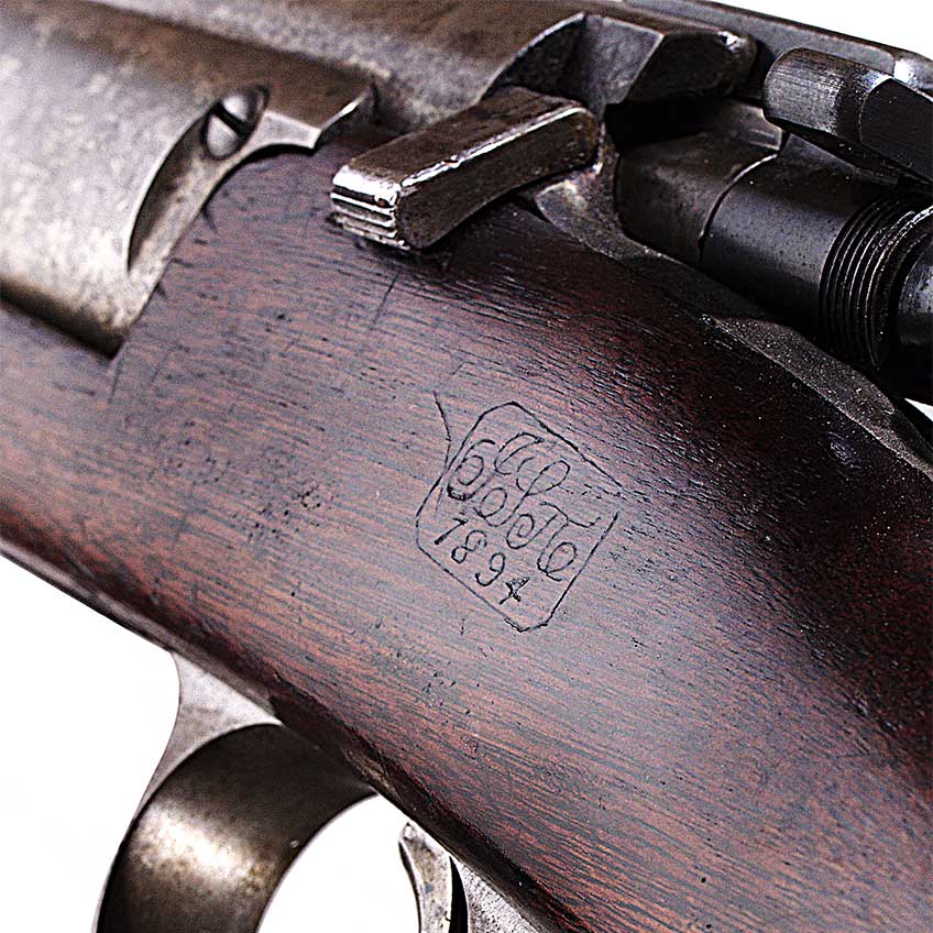 The stock cartouche and inspector’s mark of this unmodified Model 1892 rifle denotes 1894 as the rifle’s year or production.