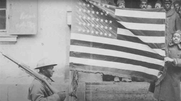 African American soldiers posing with the American flag.