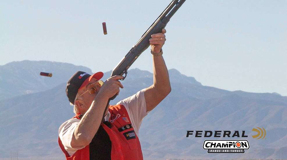 Tom Knapp professional trick speed shooting mountains behind man in red vest shooting shotgun federal champion