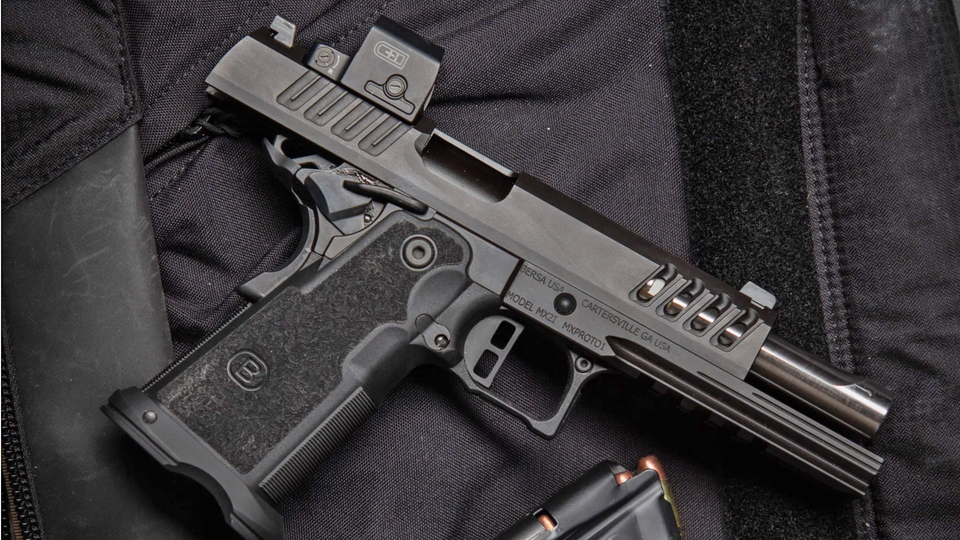 Bersa M2XI pistol resting on a black range bag with its slide locked back.