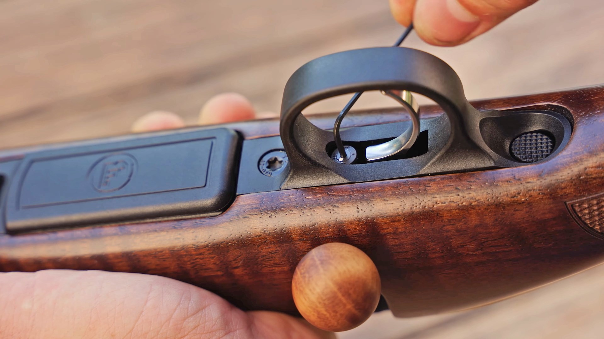 Hand turning an Allen-head screw on the underside of the CZ 600 trigger.