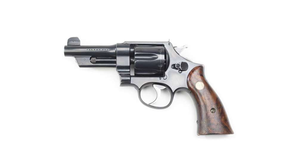 left side black revolver woode grip gold medalion inset in wood