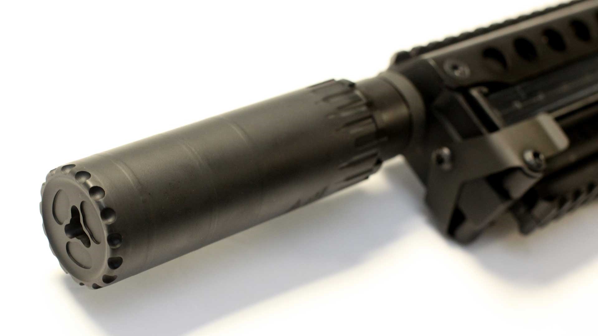 A black suppressor mounted on the muzzle of a Kel-Tec P50.
