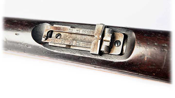 A folding, elevation-adjustable rear sight interrupts the wooden handguard on the Winchester Model 1895 Lee Navy rifle.