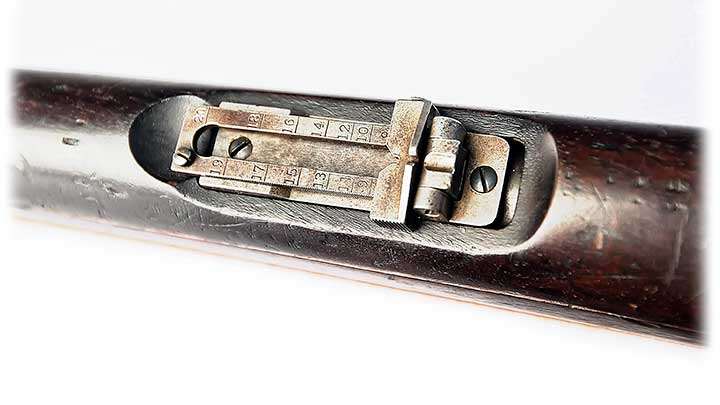 A folding, elevation-adjustable rear sight interrupts the wooden handguard on the Winchester Model 1895 Lee Navy rifle.