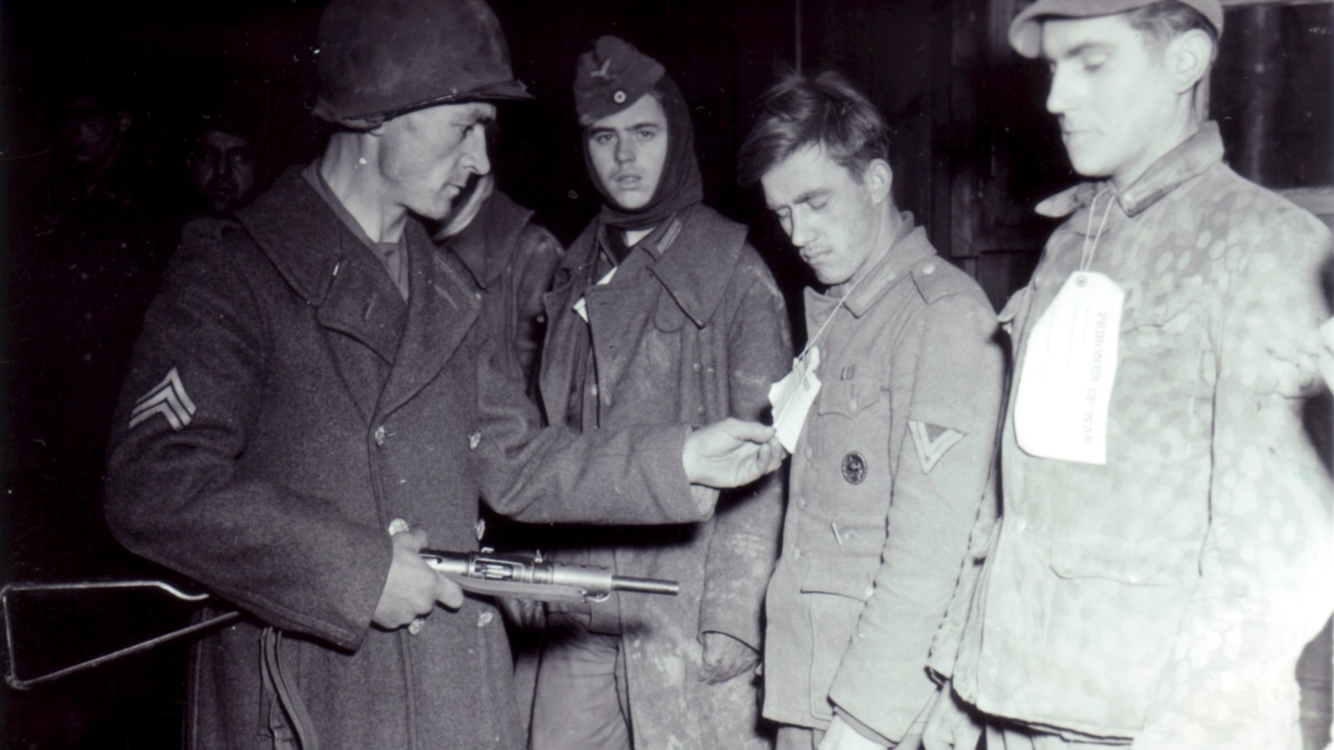 American soldier with submachine gun checking German prisoners during World War II near Ubach, Germany.