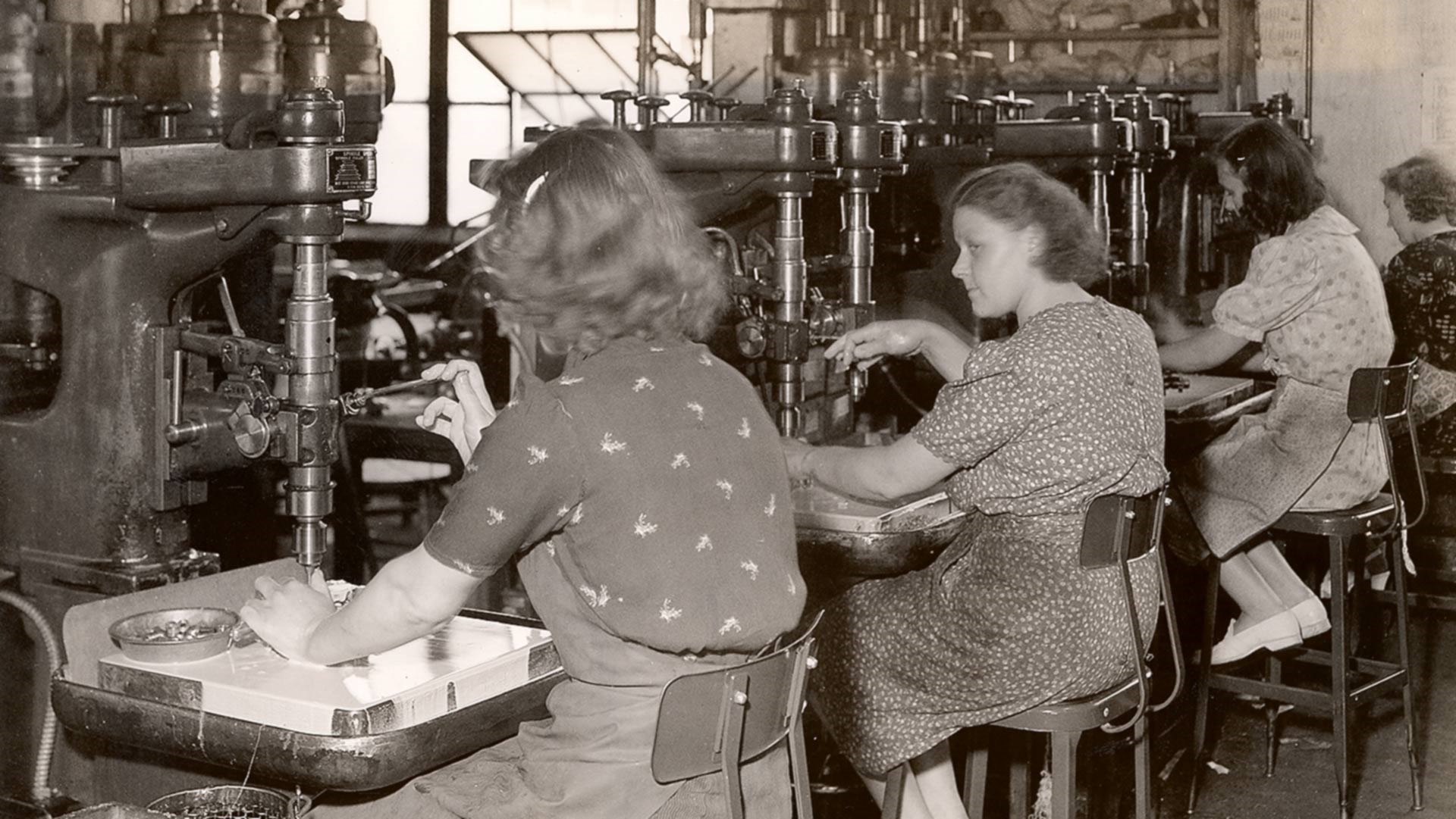 women working side-by-side in factory drilling press manufacturing world war II WWII