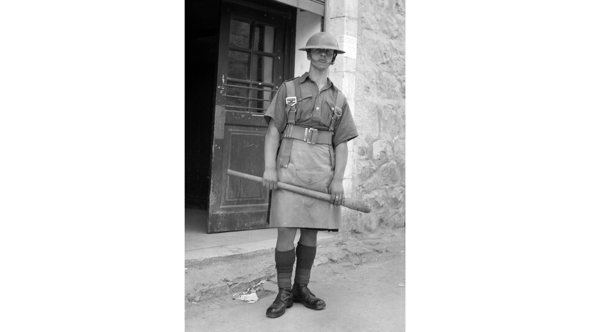 Less lethal:  A British soldier prepared for riot control with a sturdy axe-handle.  Library of Congress
