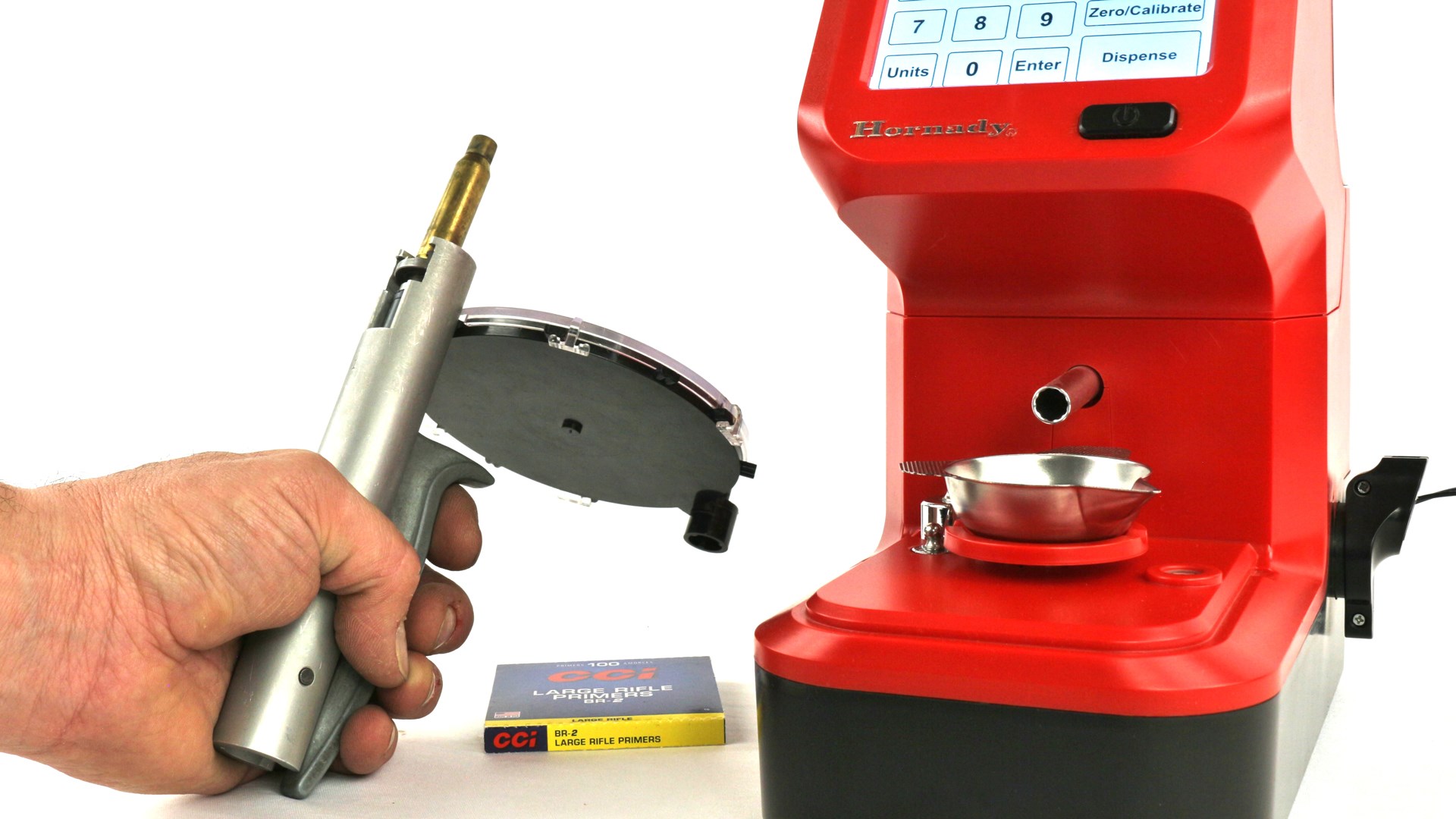 Multitasking while dispensing gunpowder from red hornady machine on left hand using priming tool