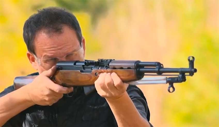 Man with shooting glasses on shooting a SKS-45 rifle.