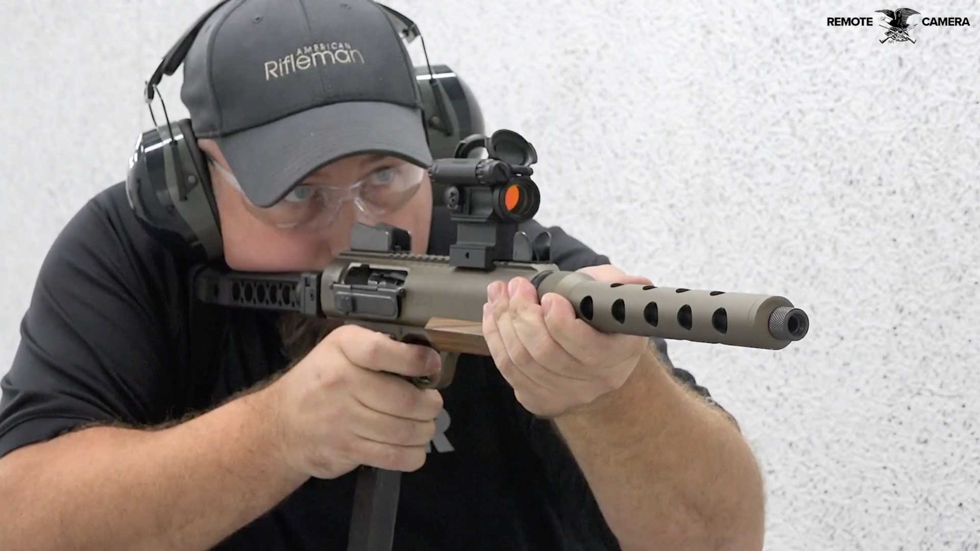 man black shirt ballcap shooting rifle carbine gun