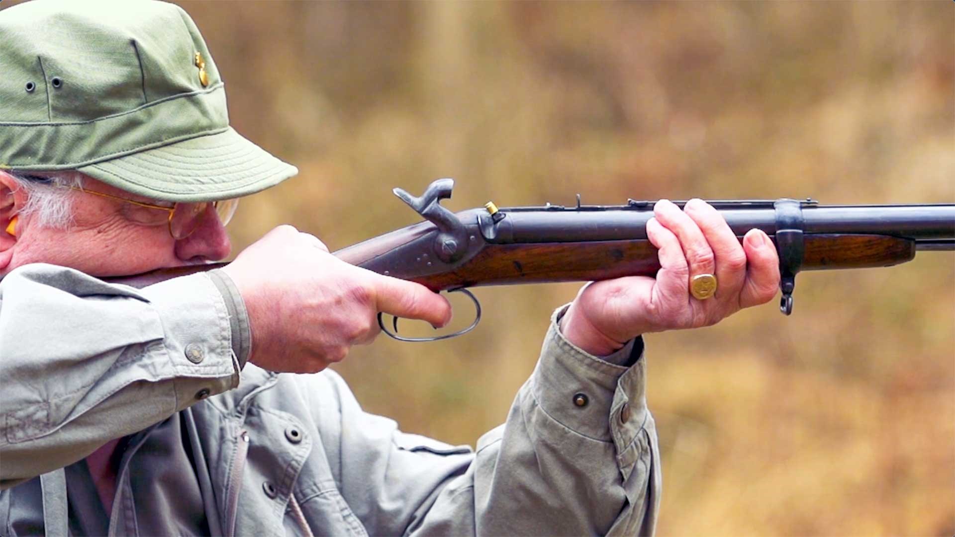 A man with a green hat shooting the Jacob Double Rifle on an outdoor range.