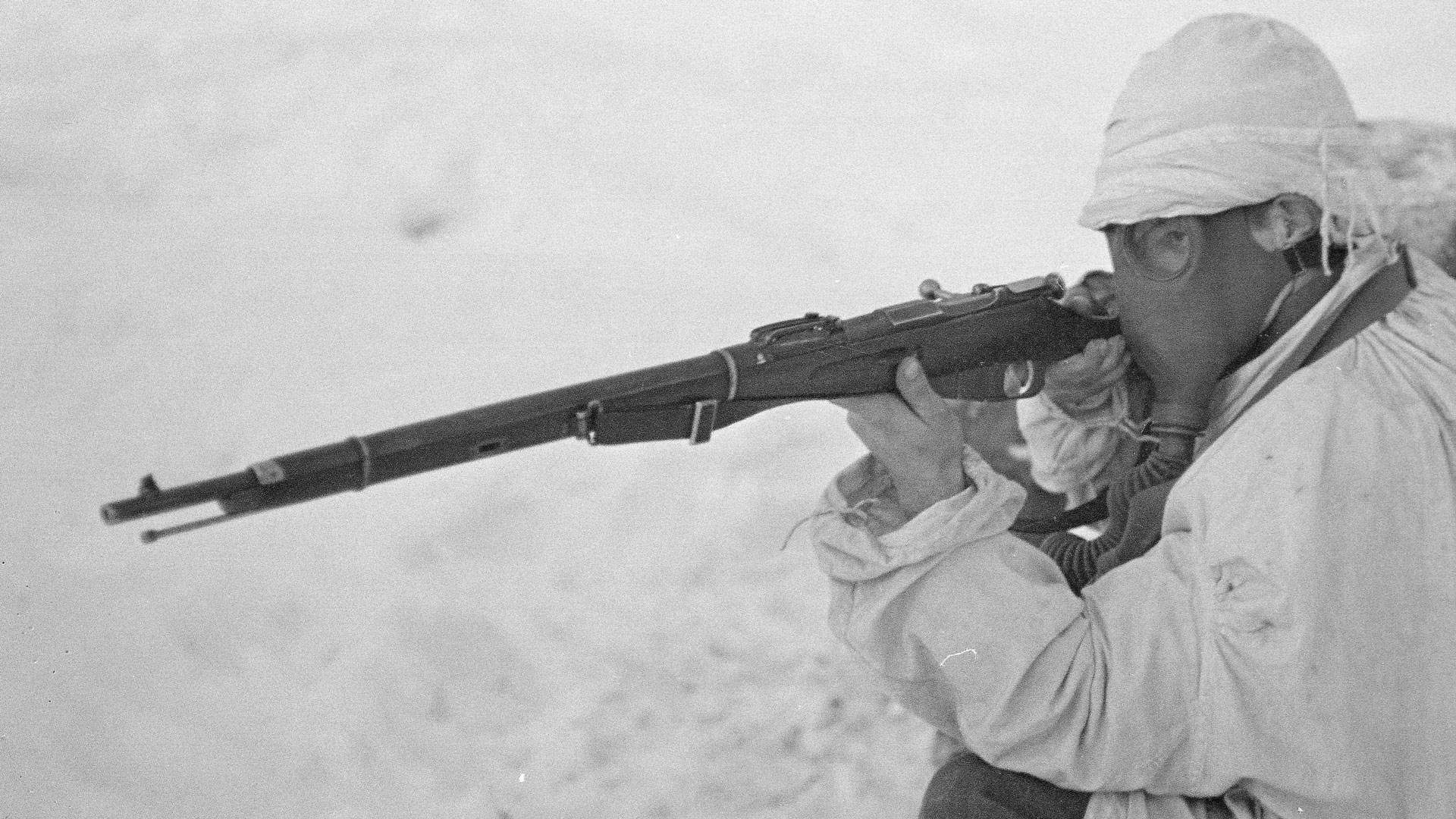 vintage finnish soldier with gas mask and mosin nagant rifle white clothing snow background