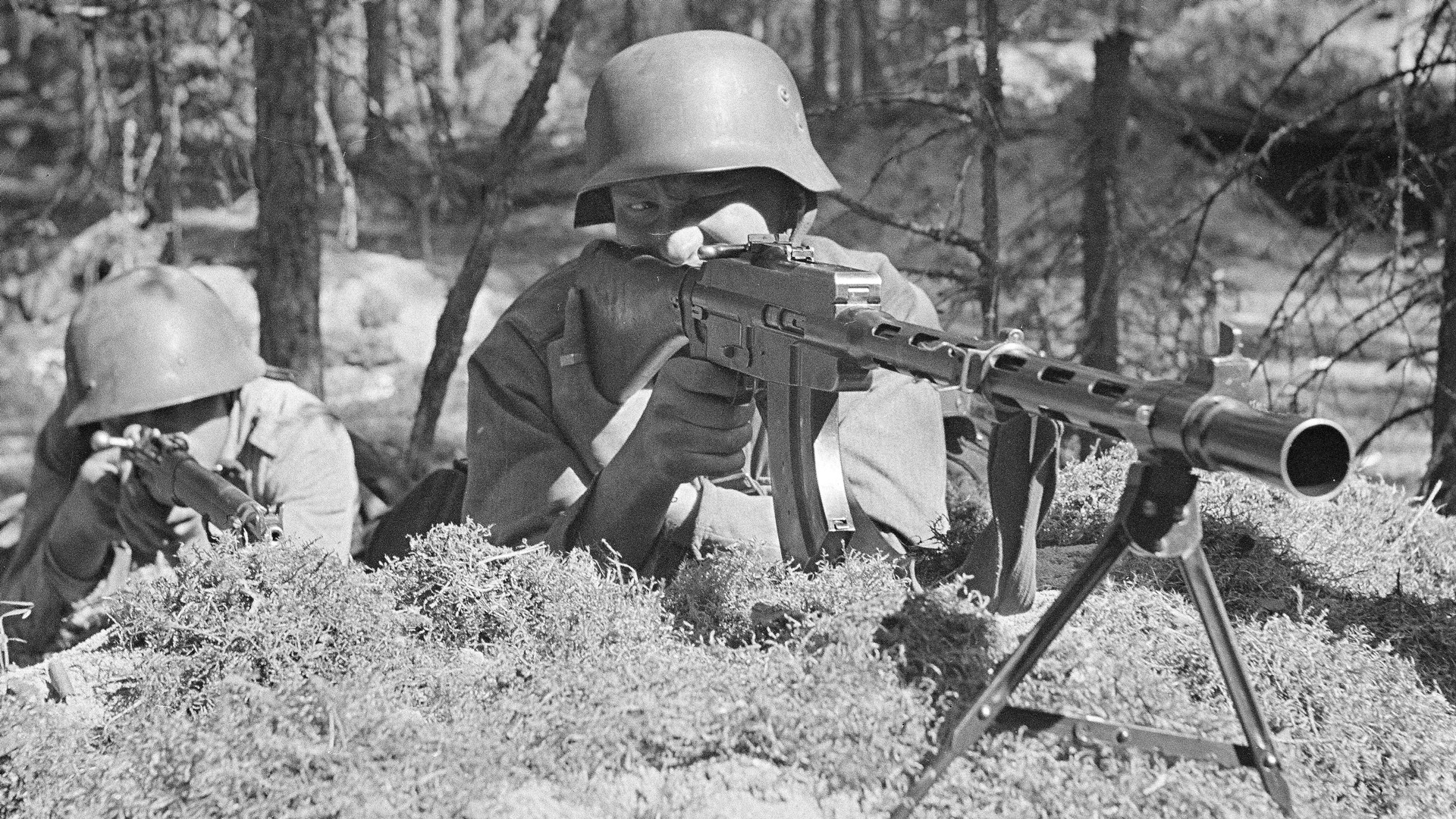 Two Finnish soldiers aiming guns mosin nagant left and M/26 light machine gun on bipod right trees background