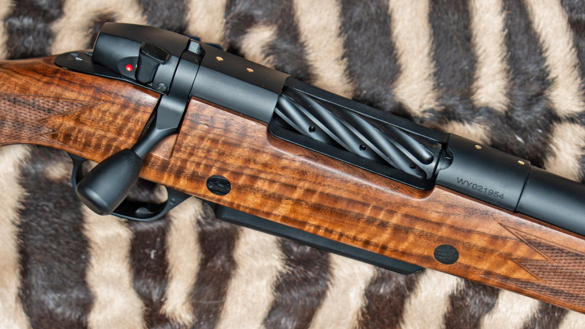 Weatherby Mark V rifle action laying on a zebra background.