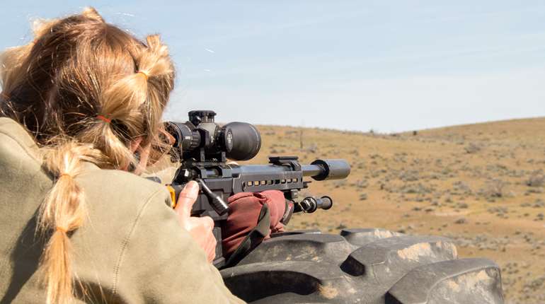 Women outside with rifle on rest
