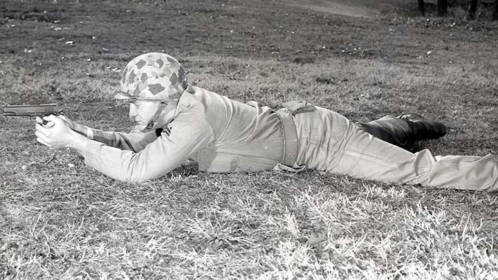 Demonstrating the approved Marine positioning for pistol shooting in the prone position.