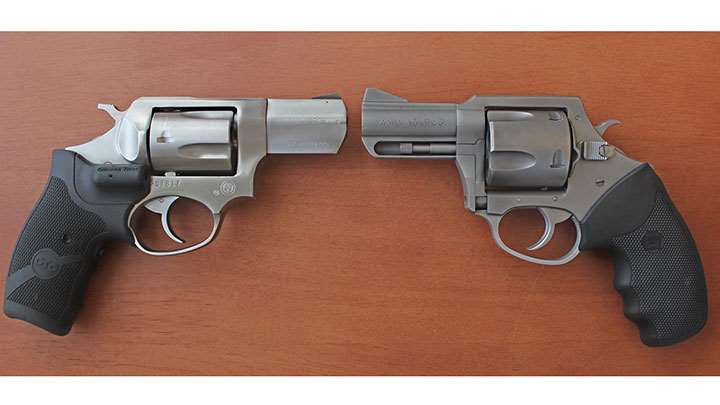 two stainless steel revolvers opposing on wood table