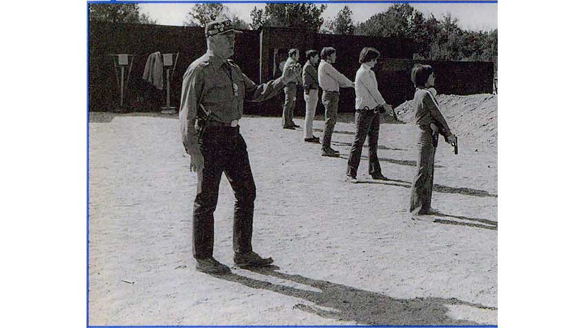 Col. Jeff Cooper standing behind a line of shooters at Gunsite Academy.