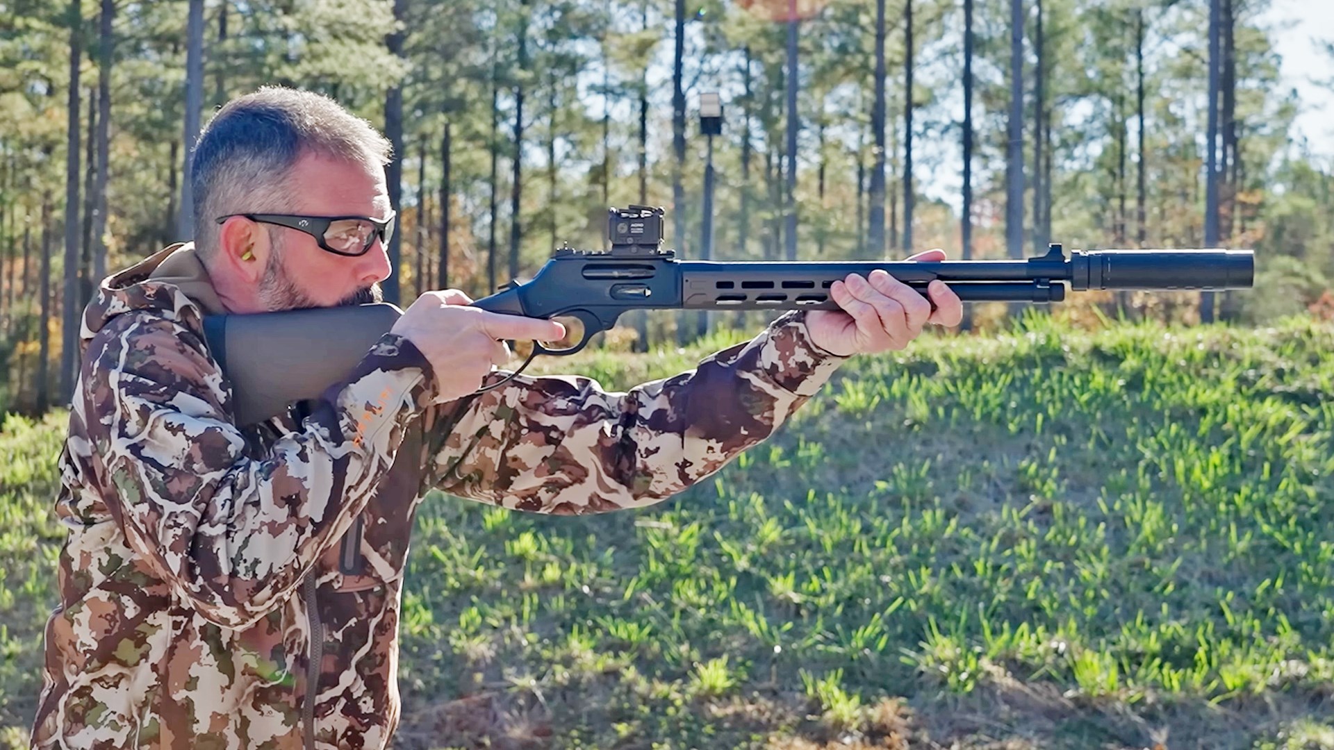 Man aiming a Henry Repeating Arms SPD CRUSR rifle.