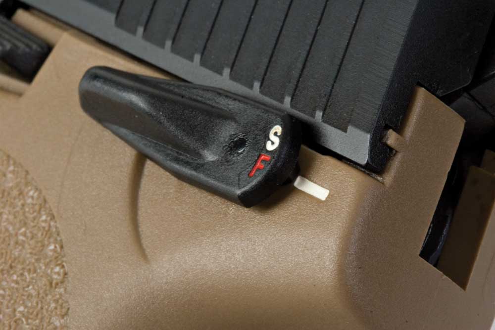 H&K USP Tactical .45 closeup safety lever red white letters tan plastic black slide metal parts gun pistol