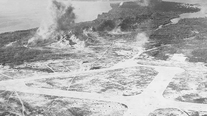 Peleliu under fire, probably during the pre-invasion bombardment, circa Sept. 12-15, 1944. Photographed from a floatplane from USS HONOLULU (CL-48). Photo looks North-East, with the airfield in the foreground and Umurbrogol Ridge in the distance, partly shrouded in smoke.  (U.S. Navy photograph #80-G-283520).