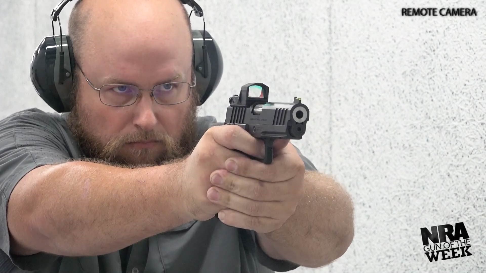 Man holding Springfield Armory Prodigy pistol shooting target range indoors safety