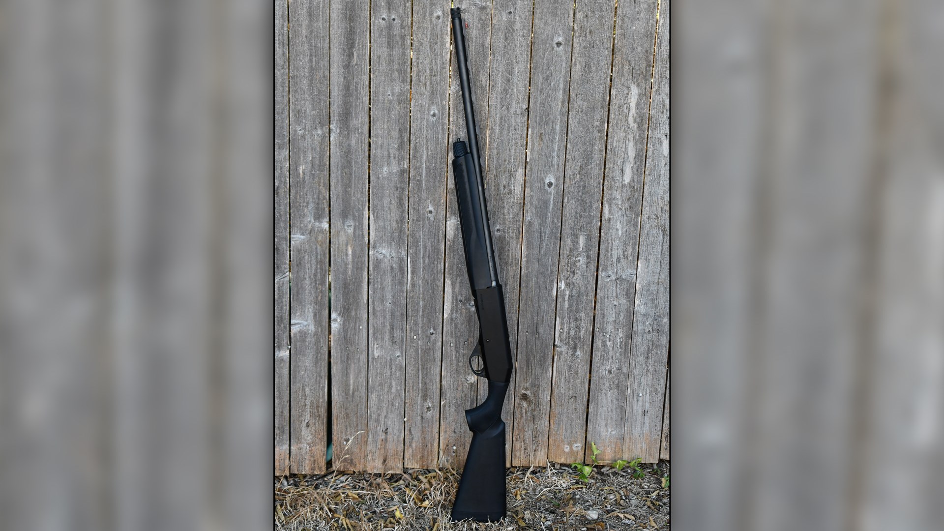 Stoeger Industries M3K 3-Gun shotgun upright agains wood fence black shotgun 12 gauge