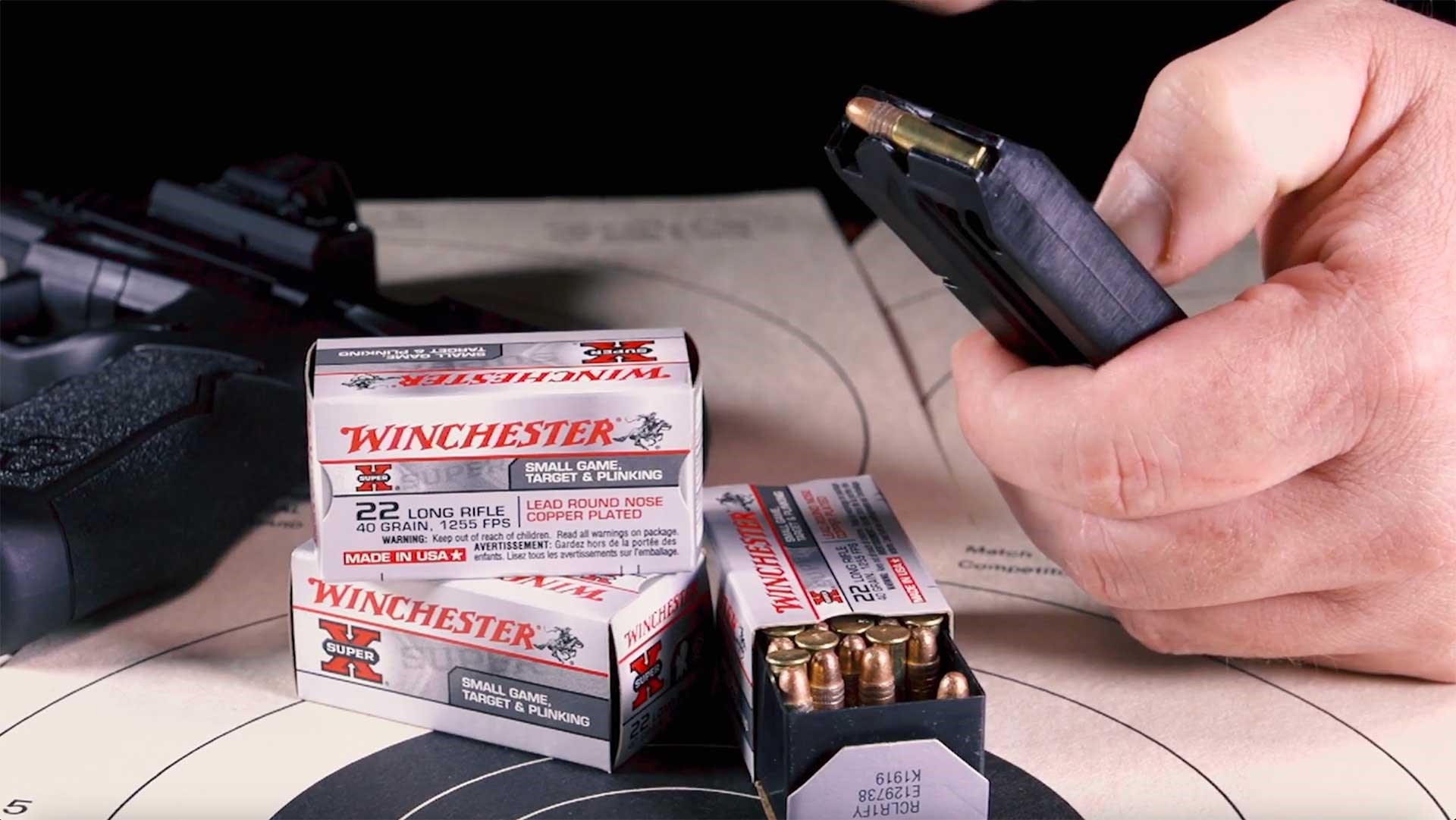 Taurus TX22 16-round magazine shown next to boxes of Winchester .22 Long Rifle cartridges.
