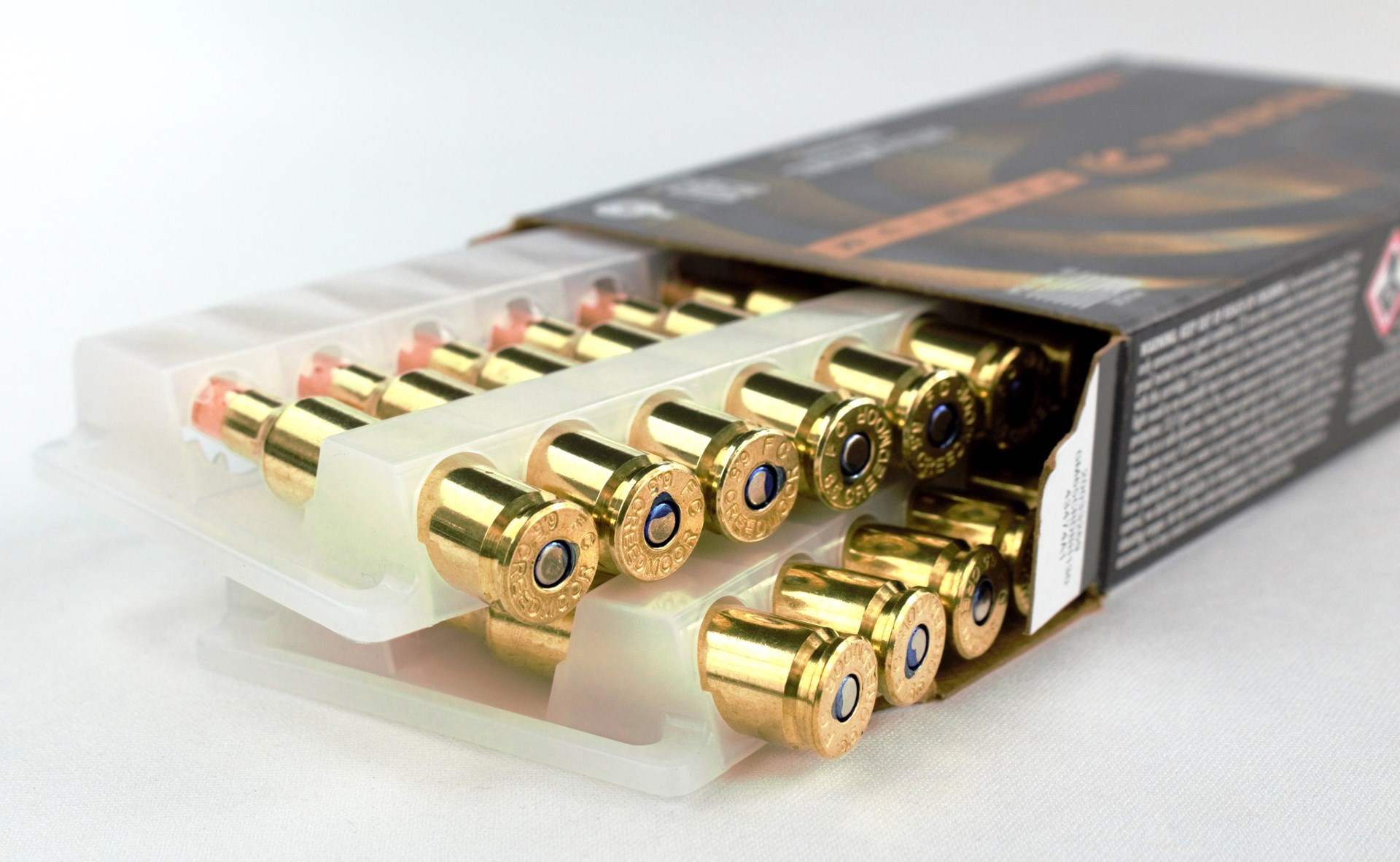 federal premium ammunition box opened arranged white background bullets cartridges brass cases plastic container