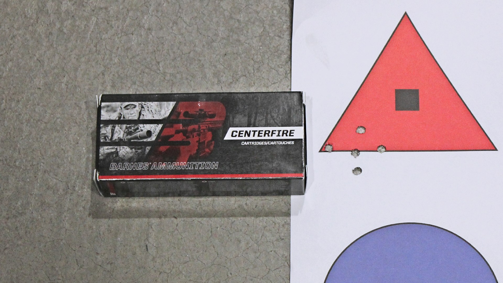 Barnes Ammunition Centerfire .223 Remington box ammo shown next to red triangle target group holes illustrating accuracy of FM Products Rancher Rifle