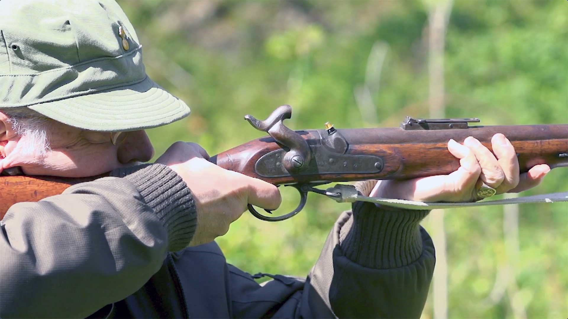 Man shooting a British Pattern 1851 Minie Rifle outdoors.