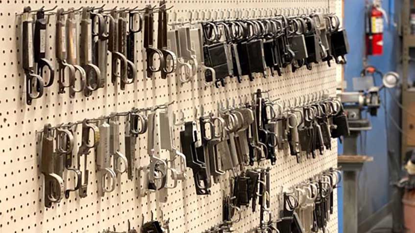 rifle bottom metal parts magazines pegboard wall scattered