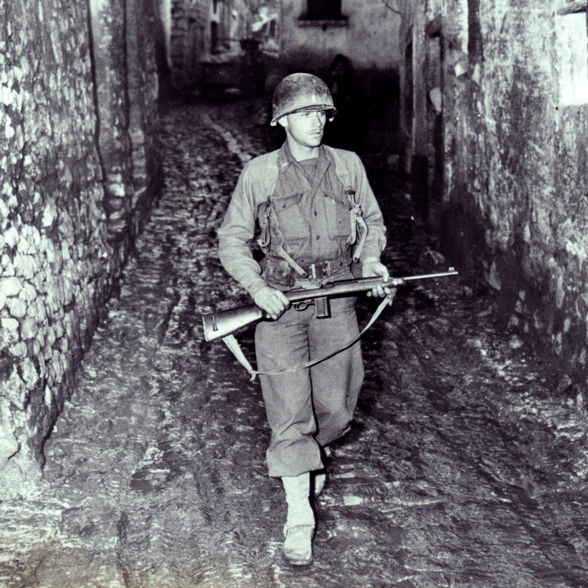 U.S. soldier WWII Italy in alley with m1 carbine