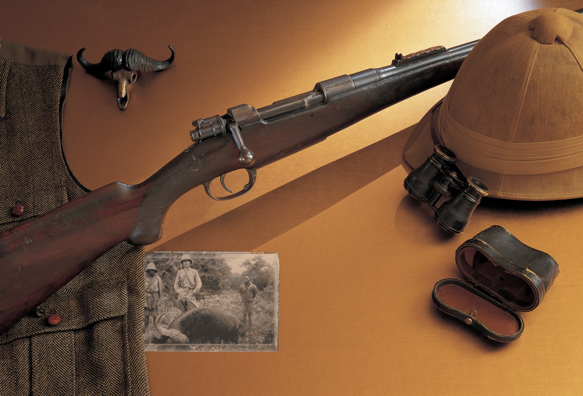 Mauser bolt-action sporter hunting rifle with hunting safari gear photograph vest hat fieldglasses
