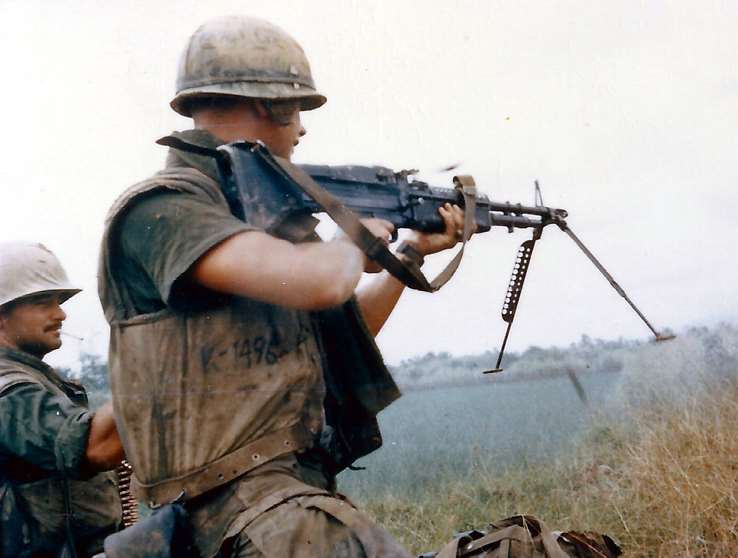 A Marine cuts loose with the 23-lb. M60 machine gun while his assistant keeps the disintegrating link ammo belt loading smoothly.
