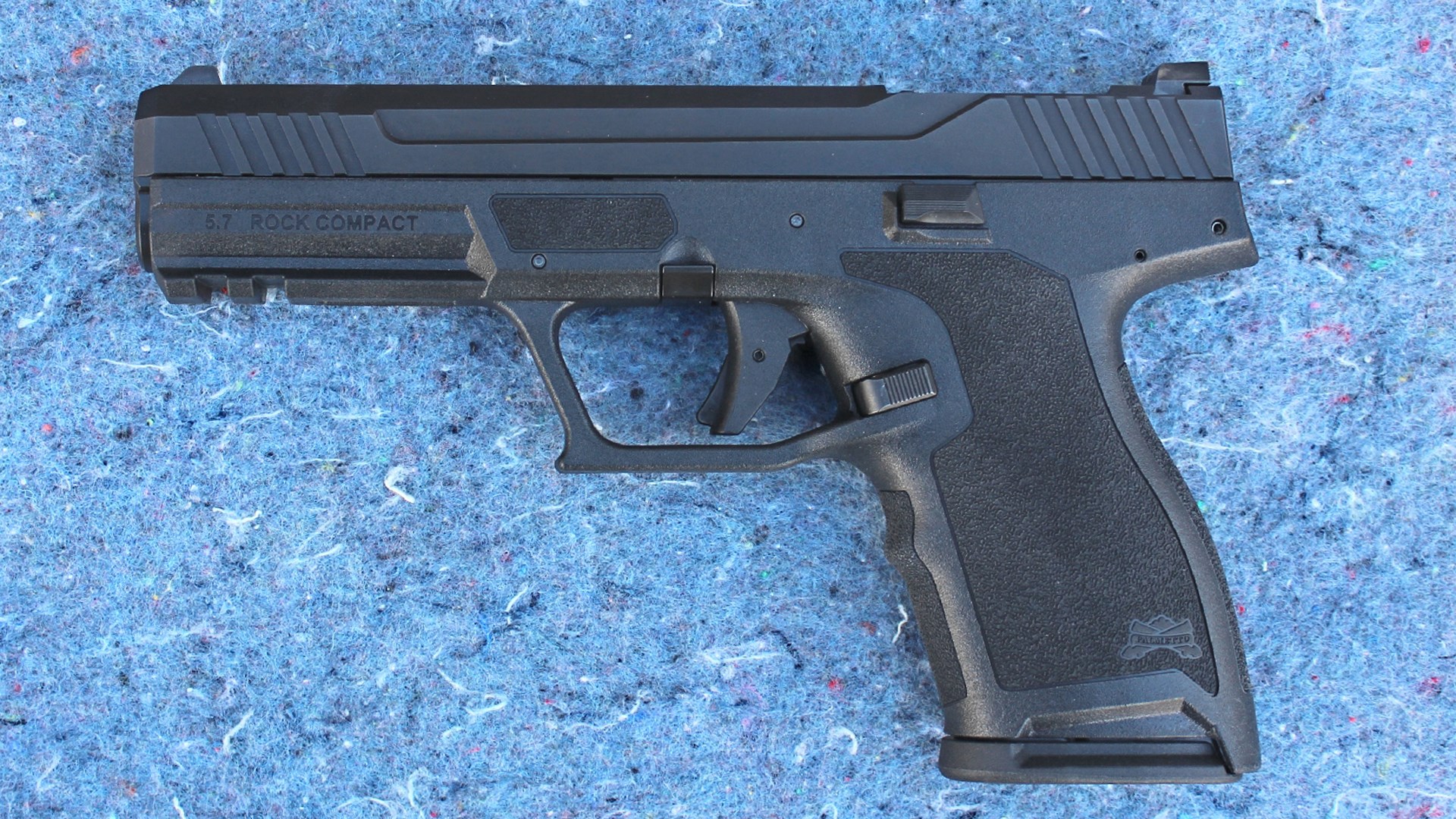 Palmetto State Armory 5.7 Rock Compact pistol left-side view black polymer frame gun shown on blue chipped stone background