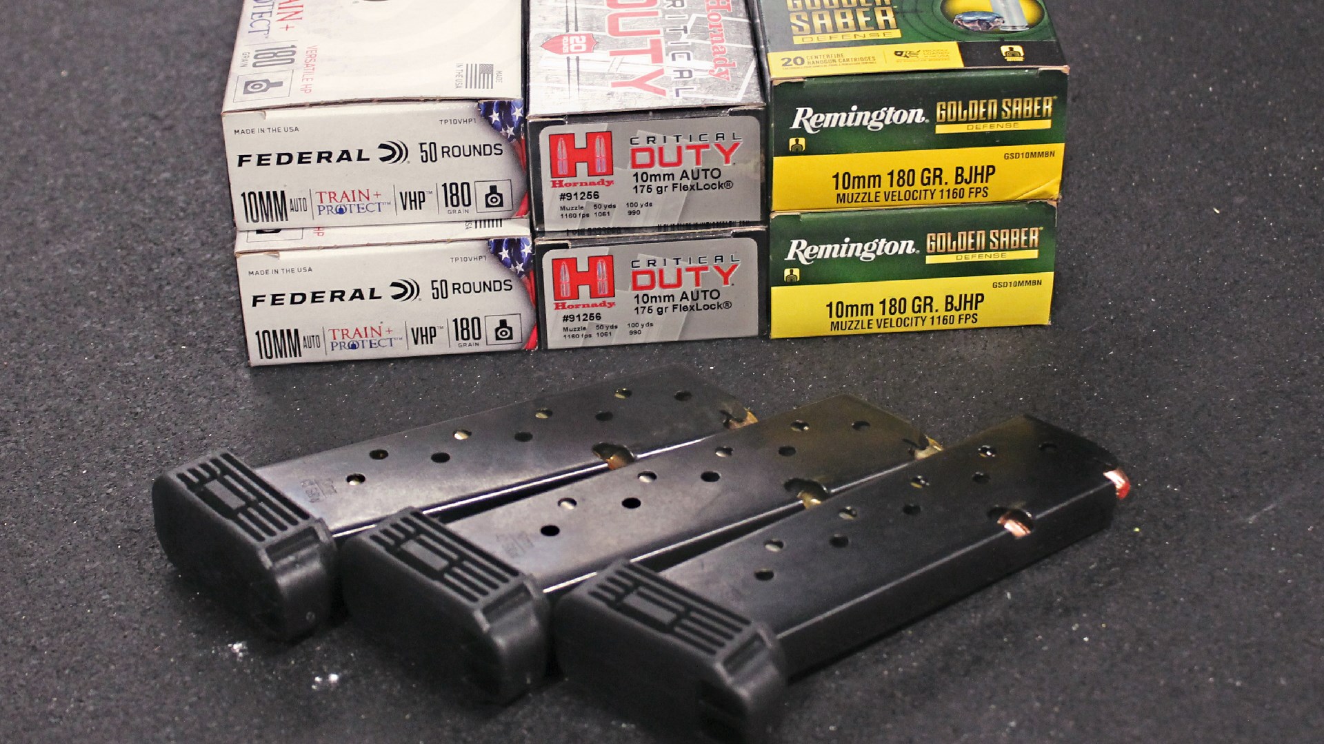 10 mm Auto ammunition boxes three types federal hornady remington shown with three pistol magazines for hi-point jxp 10