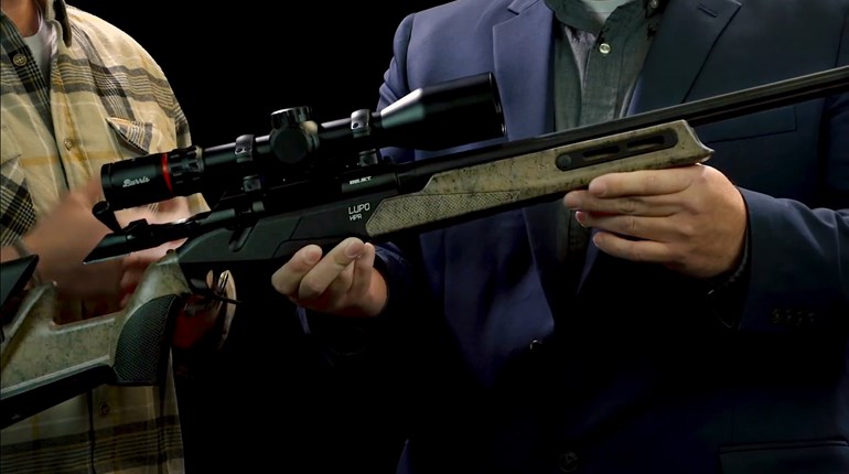 Benelli Lupo HPR bolt-action rifle black receiver barrel adjustable stock paint splatter texture held in hands 