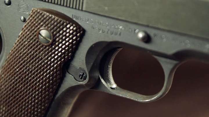 Close-up view of trigger and frame relief of Remington Rand M1911A1 pistol.