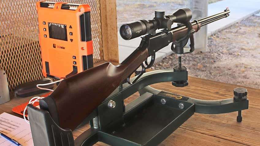 Rear view of Henry Repeating Arms Varmint Express lever-action rifle on shooting rest with orange chronograph equipment.