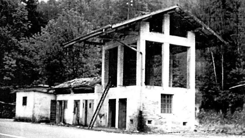 White building in ruins and old looking with no color in photo.