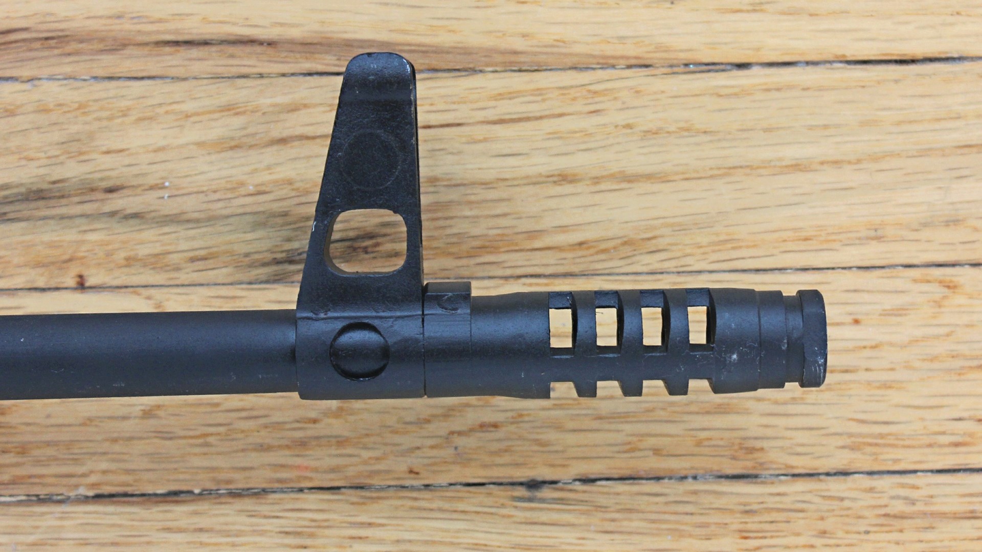 Century Arms PSL 54 muzzle brake front sight shown on wood floor