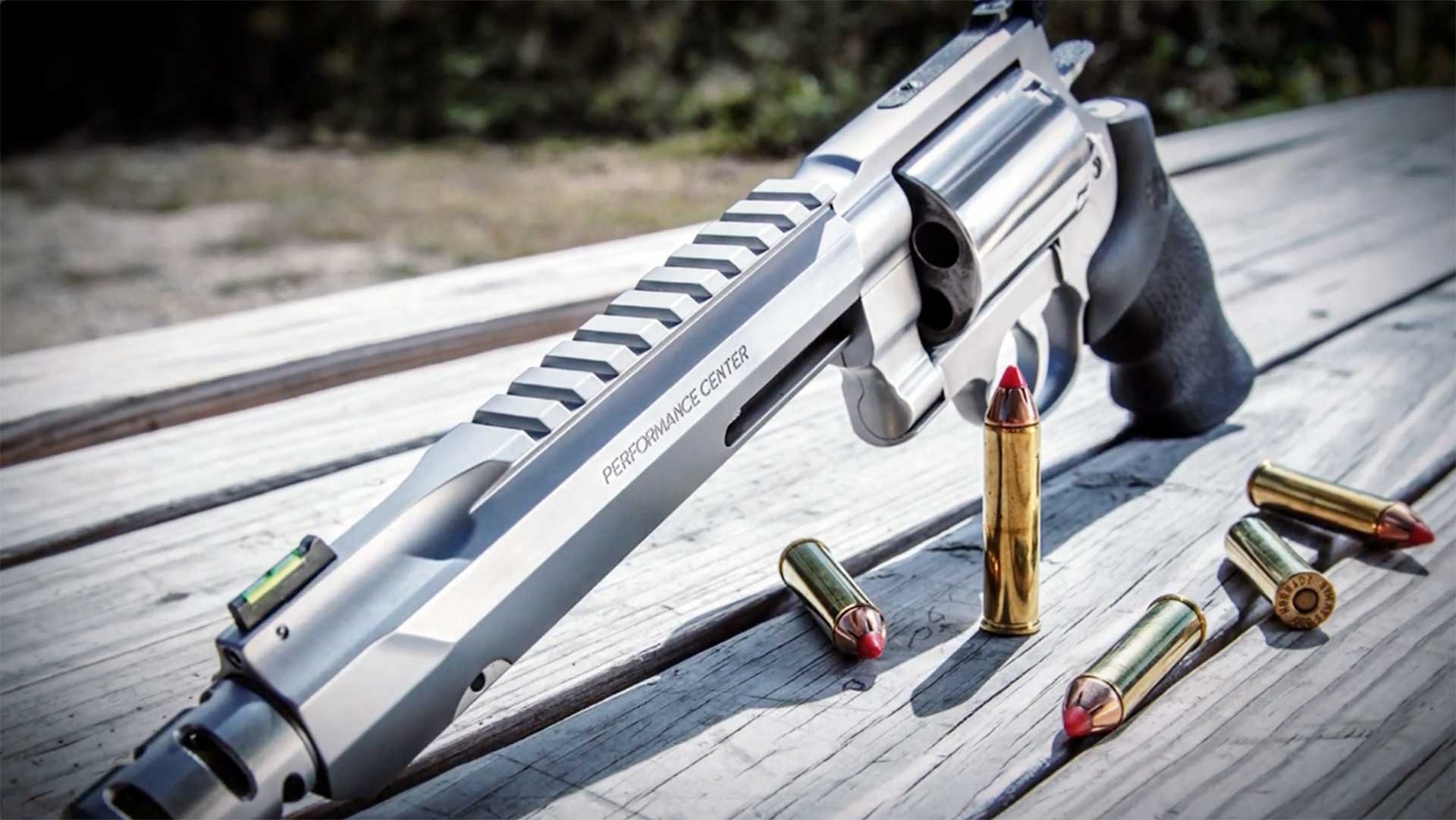 Smith & Wesson Performance Center X-Frame revolver shown on a wooden table next to .460 S&W cartridges.