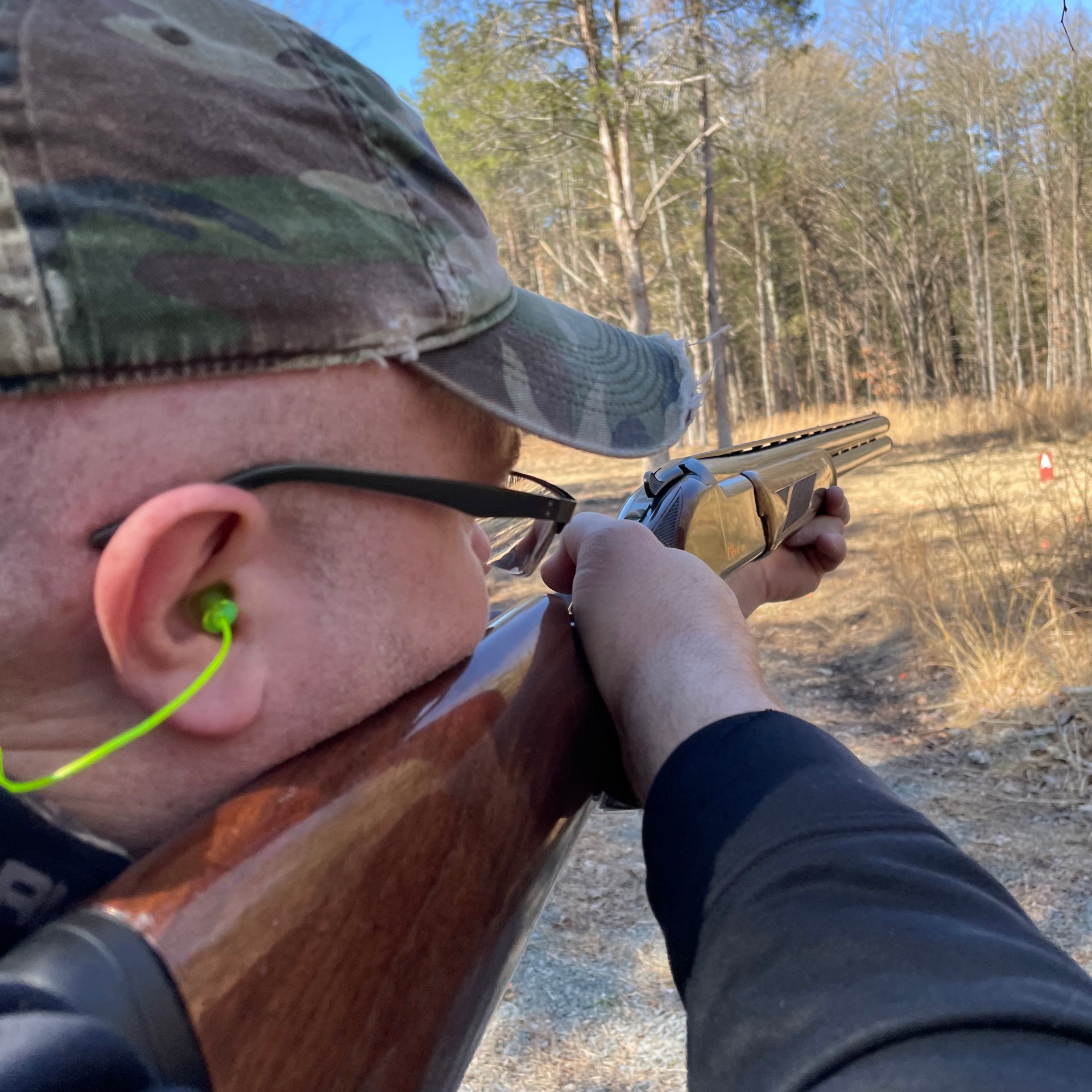 man shooting shotgun outdoors illustrating ear protection and eye protection gun safety