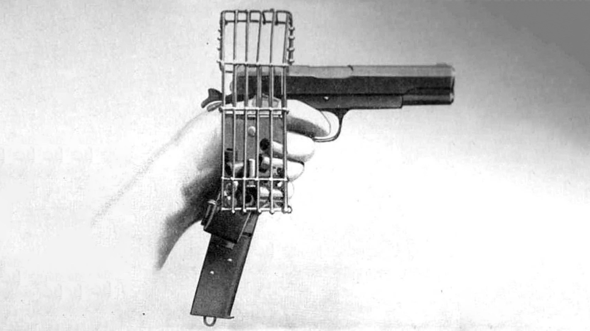 M1911 pistol drawing held in hand with brass catcher and beesley 20-round magazine
