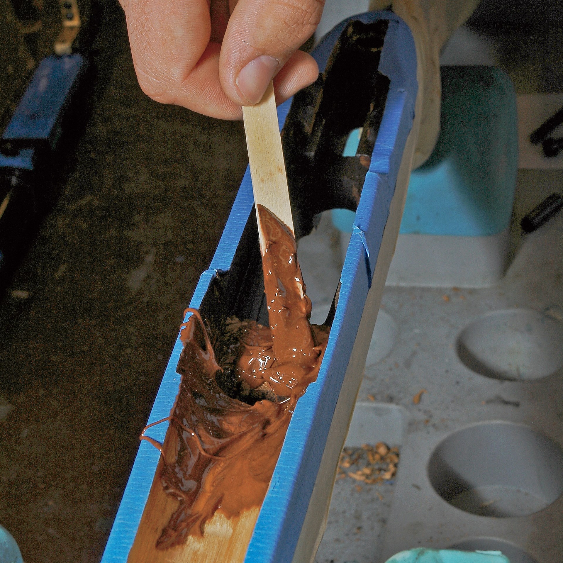 Applying bedding compound with wooden spatula